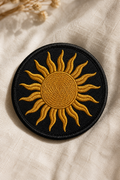 Round embroidered patch of the Zagros Sun in gold thread on black twill